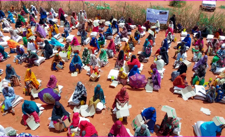 Families seated together at a HARO emergency food distribution