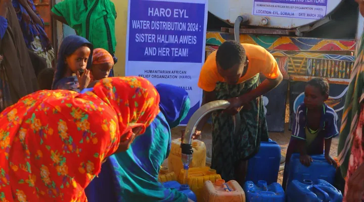 Women and children fill jerry cans from a HARO water tanker in Eyl, 2024