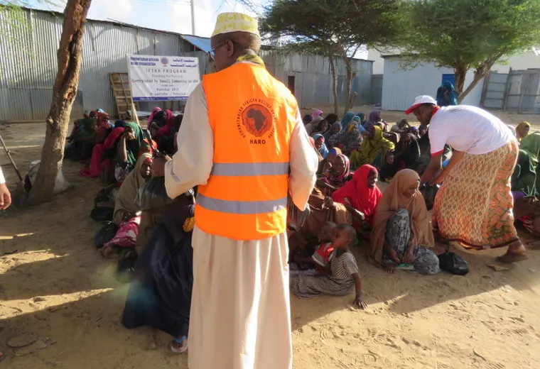 A HARO staff member addresses seated families at the Ramadan iftar program in a Mogadishu camp, 2019