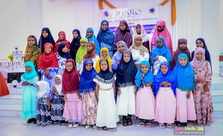 Girls in HARO's Orphan Care program gathered in front of the HARO banner at a community event