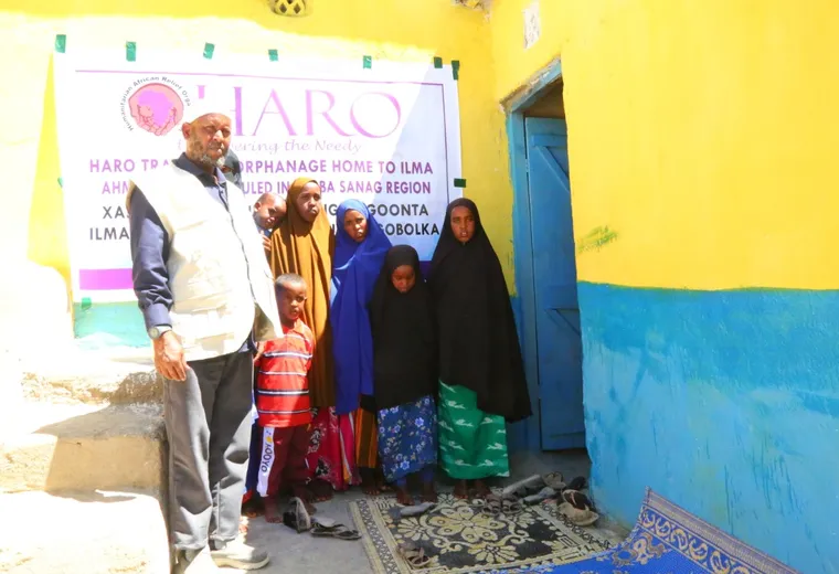 HARO staff with a mother and children in front of the orphanage home handed over in Sanaag, 2021