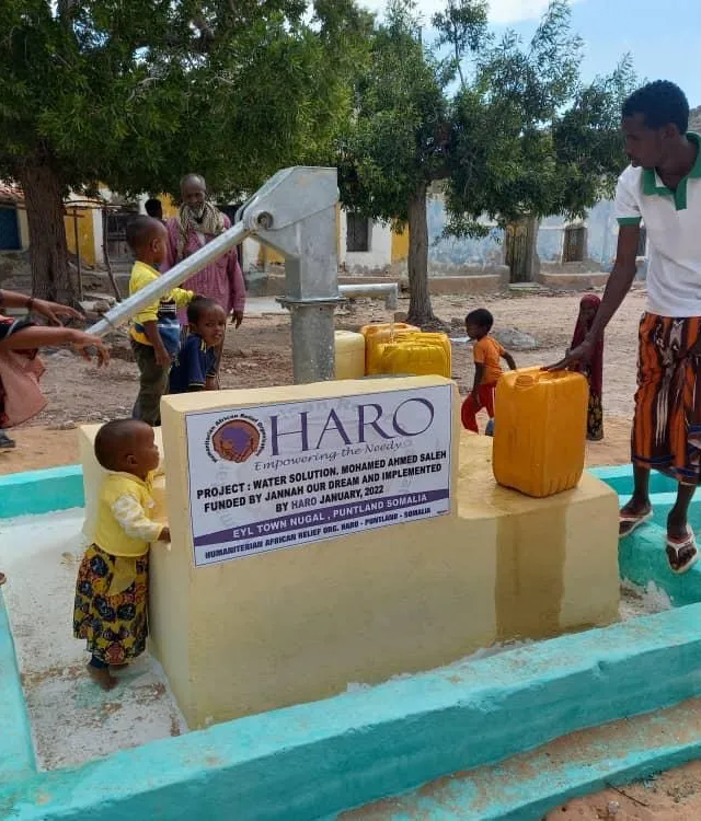 A child drinks from a HARO borehole hand pump